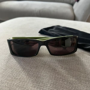 Solglasögon - Snygga solglasögon med mörkgråa bågar och gröna skalmar från Daniel Hechter. Perfekta för en stilren look med en touch av färg. De sitter ganska tight så passar ett lite mindre huvud om man inte gillar när de sitter för hårt