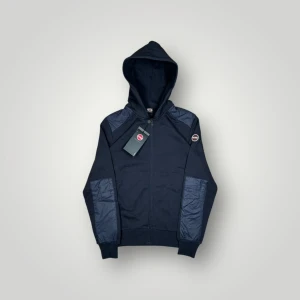 Colmar zip-hopdie  - Riktigt snygg helt ny Colmar zip-hopdie. Färg: Marinblå. Perfekt för lite kallare dagar eller sena sommarkvällar. Strl: S. 📐Armhåla till armhåla: 47cm Längd: 66cm Armlängd: 65cm 