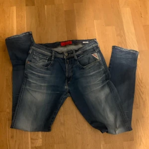 Blå jeans från Diesel - Snygga blå jeans från replay  med en klassisk femficksdesign och diskreta slitningar. Perfekta för en avslappnad stil. Märkeslappen syns tydligt på baksidan. Storlek 34 34