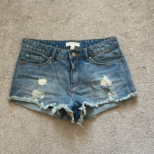 Blå low waist jeansshorts  - Säljer ett par snygga blå lågmidjade jeansshorts från Springfield. 