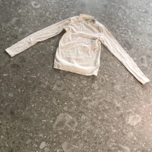 Vit polotröja från Zara - Säljer en enkel och stilren vit polotröja från Zara i mjukt material. Tröjan har långa ärmar och en klassisk polokrage, perfekt att styla till olika outfits. Passar dig som gillar minimalistisk stil.