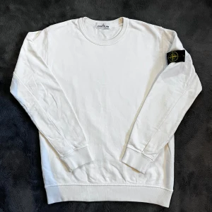 Stone Island sweatshirt - Säljer en stilren vit sweatshirt från Stone Island med klassisk logotyp-patch på vänster ärm. Storlek L, skick: 9/10. Patchen har varit en sväng i tvätten annars väldigt bra skick. Pris går att diskutera✅ 