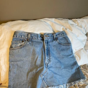 Jeanskjol från Levi's - Säljer en klassisk blå jeanskjol från Levi's med regular fit. Knappt använd och ser ut som ny