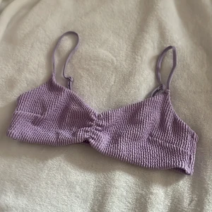 Ljuslila ribbad bikiniöverdel💜 - Säljer en ljuslila bikiniöverdel med ribbad struktur och twistad detalj framtill. Justerbara axelband för perfekt passform. Perfekt för sommardagar vid stranden eller poolen! I storlek 38 men liten i storleken så skulle säga att den passar mer storlek 34. Skriv gärna om ni har frågor🫶🏼☺️