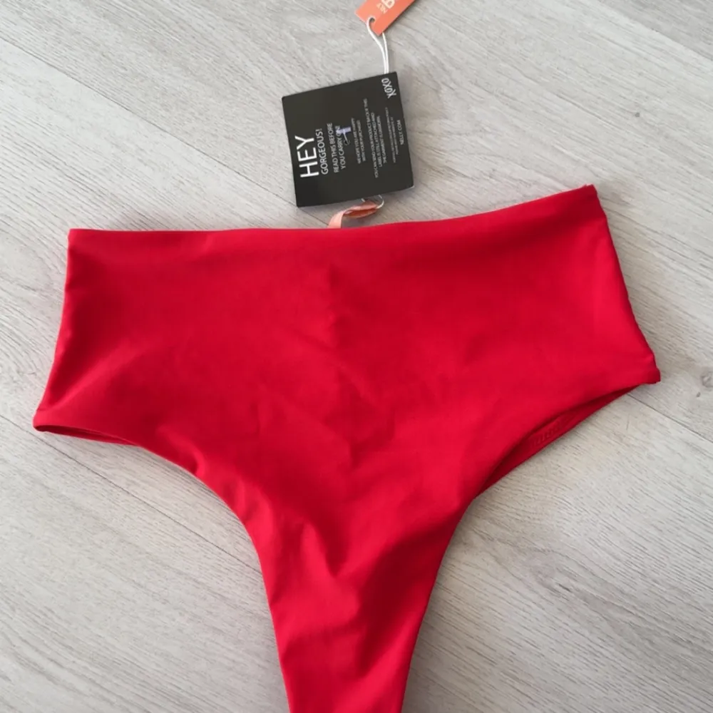 Röd bikiniunderdel från nelly. Aldrig använd så prislappen är kvar. Storlek S. Muu.