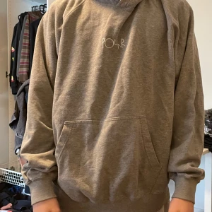Polar Hoodie - Grå hoodie från polar. Hål nere på baksidan och lite slit i ena armhålan, annars fint skick. Inga fläckar. Personen i bilden är runt 175. 