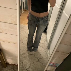 Lågmidjade utsvängda jeans - Säljer ett par blå jeansbyxor från Iroce med superfina mönstrade bakfickor. Byxorna har låg midja, utsvängda. Det står ingen storlek, men måtten är W: 87 (jag har mätt runt jeansen och inte tvärs över) och L: 90cm🥰