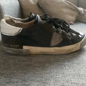 Svarta Philip modell - Snygga svarta sneakers med vita detaljer och snörning. Skorna har en rund tå och en robust sula. Perfekta för en avslappnad stil. Har lagt in en arigato sula då den är skönare. Pris kan diskuteras och jag kan gå ner ganska mycket i pris vid en snabb affär! Byte går bra