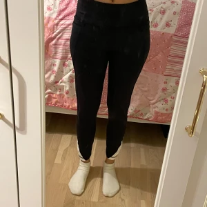 Svarta träningstights från SOC - Svarta tights från SOC med hög midja och vita detaljer vid anklarna. Perfekta för träning med stretchigt material som andas och sitter tight mot kroppen.