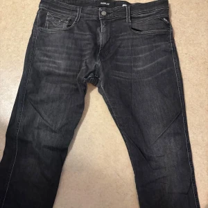 Svarta jeans från Replay - Snygga svarta jeans från Replay med en klassisk femficksdesign. De har en knappgylf och är tillverkade i ett slitstarkt material. Perfekta för en stilren look.