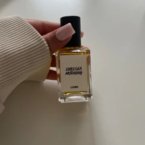 Chelsea Morning parfym från Lush - Chelsea Morning från Lush är en parfym i en stilren, rektangulär glasflaska med svart lock. Flaskan har en vit etikett med svart text och innehållet är ljust gult. Perfekt för dig som gillar unika dofter och snygg design. OANVÄND