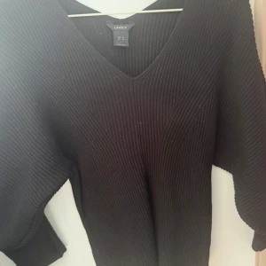 Svart ribbad stickad tröja Lindex - Svart stickad tröja från Lindex i storlek M. Tröjan har v-ringning, långa ärmar och är ribbstickad för en snygg struktur. Är figursydd så framhäver figurerna på ett snyggt sätt 