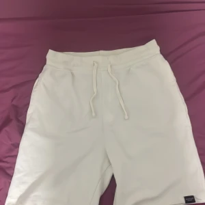 Vita shorts med snörning från Zara - Snygga vita shorts från Zara i mjuk bomull med relaxed fit och snörning i midjan. Perfekta för sommardagar, med fickor fram och en bakficka för en clean look. Passar dig som gillar enkel och stilren streetwear.