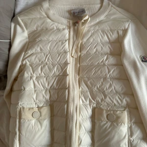 Vit dunväst från Moncler - Jacka från moncler. Storlek 2, vilket passar mig som brukar bära s/m. Köpt här på plick men har endast använt den ett par gånger så inga defekter. Priser går att diskutera