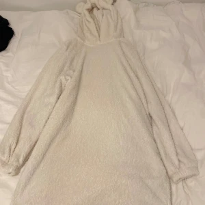 Vit fluffig hoodie med öron från SHEIN - Supermjuk och oversized vit hoodie från SHEIN med fluffigt teddy-material. I storlek XL för o ha den overaized och lång. Huvan har söta öron och tröjan har långa ärmar med resår vid handlederna. Perfekt för myskvällar eller när du vill vara extra cozy.