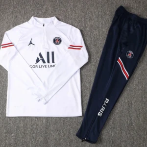 PSG träningsset med half zip - Snyggt PSG träningsset med vit långärmad tröja med half zip och marinblå byxor. Båda delarna har klubbens logga och röda, vita och blå detaljer. Perfekt för fotbollsträning eller chill. Tröjan har dragkedja vid halsen och byxorna har dragkedja vid benslut.