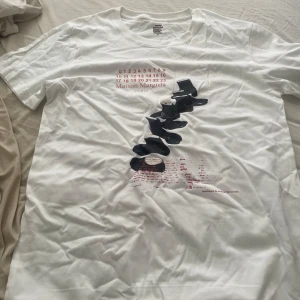 Maison Margiela vit t-shirt  - Vit t-shirt från Maison Margiela med unikt svart och rött tryck framtill. Pris kan diskuteras i dm