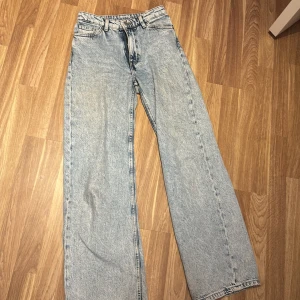 Ljusblå wide jeans från Monki - Säljer ett par ljusblå jeans från Monki i storlek 25. De har en rak och wide passform med hög midja och klassiska fem fickor. Jeansen är tillverkade i bomull och har en snygg tvättad look med Monki-lapp bak i midjan.