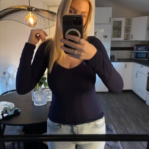 Mörkblå långärmad topp med v-ringning - Säljer en mörkblå långärmad topp med v-ringning och diskret spetskant vid halsen från Nelly. Aldrig använd, strl S💙