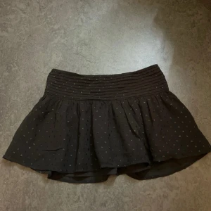 Svart prickig kortkjol Gina Tricot - Supersöt svart kortkjol från Gina Tricot Young med glittriga prickar och bred, veckad midja. Kjolen har en lätt utsvängd form och är perfekt för dig som gillar en trendig och lekfull stil. Kan tyvärr inte visa hur den sitter på då den blivit för liten. Har använt den 1-4 gånger så fortfarande i ett väldigt bra skick. Storlek är 158/164. 