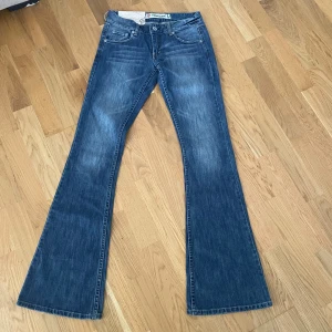 Blå jeans  - Supersnygga lågmidjade bootcut jeans i färgen blå! Vintage och går inte att få tag på längre! Xxs , midja: 33 cm, midjehöjd: 19 cm, innerben: 84 cm