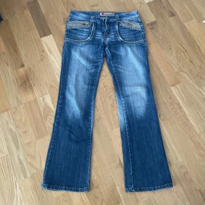 Blåa jeans - Supersnygga lågmidjade bootcut jeans i färgen blå! Vintage och går inte att få tag på längre! M , midja: 38 cm, midjehöjd: 20 cm, innerben: 77 cm