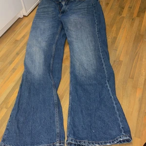 Wide jeans från Reserved, blå denim - Blåa jeans från Reserved i klassisk denim med breda ben och normal midja. Modellen är loose fit med fickor där bak, dragkedja och knapp framtill. Perfekta för dig som gillar en avslappnad och trendig look.