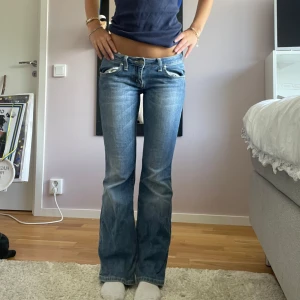 Lågmidjade bootcut jeans blå - Snygga blå jeans med låg midja och bootcut passform. 