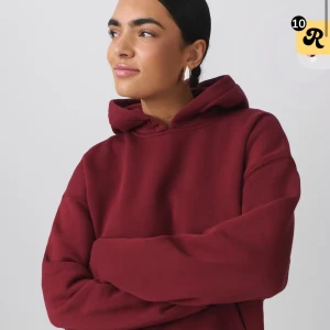 Vinröd hoodie med huva - Säljer en vinröd hoodie med huva och lång ärm. Tröjan har en loose passform och är tillverkad i mjukt material, perfekt för kyliga dagar. Enkel och stilren design utan tryck eller detaljer.