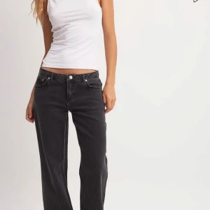 Svarta jeans från NA-KD - Snygga svarta jeans från NA-KD med en klassisk femficksdesign. De har en rak passform och är lågmidjade. Perfekta för en avslappnad look. Knappt använda. Nypris 700kr!💗Jag säljer även ett par blåa i en storlek större.
