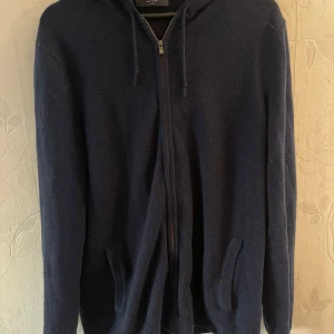 Kashmir hoodie - Säljer en stilren mörkblå hoodie från Charles Tyrwhitt. Tröjan har en dragkedja framtill och en klassisk huva med dragsko. Perfekt för kyliga dagar och ger en avslappnad look.