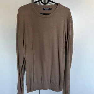 Beige tröja från Dressmann - Säljer en stilren beige tröja från Dressmann i Supima bomull. Tröjan har en klassisk rund hals och långa ärmar, perfekt för en avslappnad men snygg look. Passar bra till både jeans och chinos.