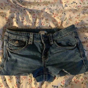 Blå jeansshorts - Säljer ett par snygga blå jeansshorts med fransiga kanter. De var igentligen jeans från Gina tricot som jag sydde om. Shortsen har klassisk femficksdesign och knappar fram. Perfekta för en avslappnad sommarlook! ⚠️⚠️⚠️VARNING: De var storlek 164, men de har blivit *lite* mindre⚠️⚠️⚠️PRIS KAN DISKUTERAS ❤️✌️