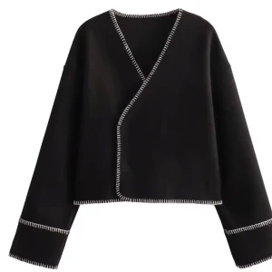 Svart omlottjacka med vita detaljer - Snygg svart omlottjacka från ginatricot med vita sömmar som ger en cool kontrast. Jackan har en croppad passform och långa ärmar, perfekt för en stilren look.