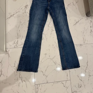 Blå jeans med bootcut - Snygga blå jeans med bootcut-stil. De har en klassisk femficksdesign och en bekväm passform. Perfekta för en avslappnad look.