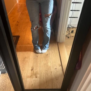 Blå jeans med slitningar från Zara - Säljer ett par blå jeans från Zara med coola slitningar på knäna. Rätt så använda men snygga!! Passar mig som är ca 164.