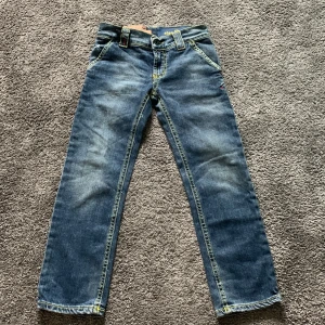 Blå jeans från Dondup - Snygga blå jeans från Dondup i klassisk denimstil. De har en rak passform med fem fickor och kontrasterande sömmar. Perfekta för en avslappnad look. Size 150 nästan helt nya