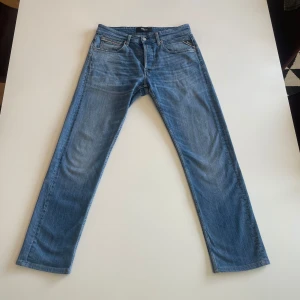 Blå jeans från Replay - Snygga blå jeans från Replay i modellen Grover. De har en klassisk femficksdesign och en knappgylf. Modellen är Grover och storleken är w30 l32
