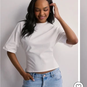 Vit kortärmad topp med knyt - Säljer en t shirt från nelly med knytning i ryggen, storlek xs. Aldrig använd, skriv för mer bilder🌸