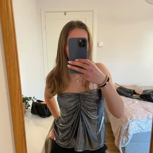 Glittrig silver tubtopp - Snygg glittrig tubtopp från H&M, i storlek M💗 Har sytt in sidorna för att den skulle passa mig bättre, men går enkelt att sprätta upp vid behov, därav priset💗💗💗Skriv för frågor