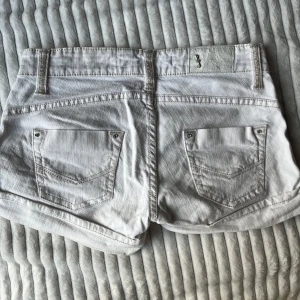 Vita lågmidja jeansshorts shorts - Säljer ett par vita shorts med låg midja. Storlek 34/XS!