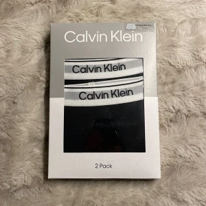 Svarta Calvin Klein kalsonger 2-pack - 2-pack svarta kalsonger från Calvin Klein med klassisk vit resår och logga runt midjan. Snygg och stilren design som passar perfekt till vardags. Mjukt och stretchigt material för extra komfort. Helt oanvänd!! 