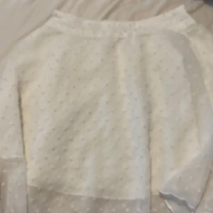 Vit prickig blus från SHEIN - Säljer en söt vit blus från SHEIN med diskreta prickar i tyget. Blusen har långärmade ärmar och är gjord i ett lätt, luftigt material som känns fräscht och passar perfekt till vår och sommar. Enkel att matcha med både jeans och kjol.