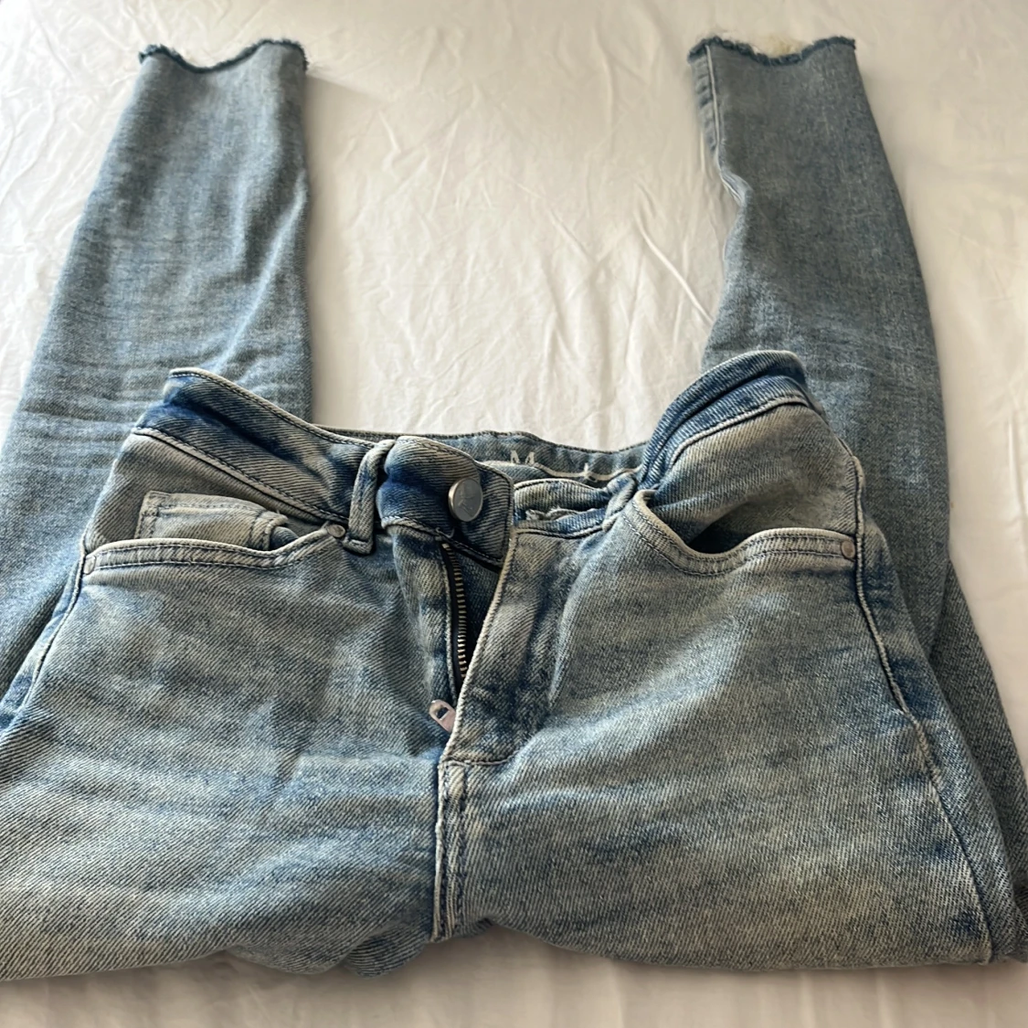 Ljusblå raka jeans med råa kanter