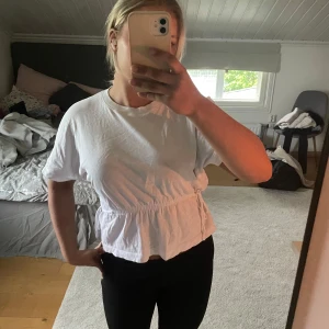 Vit t-shirt med knyt i midjan - Superfin vit blus/T-shirt från HM! Säljer pga för liten, knappt använd💕