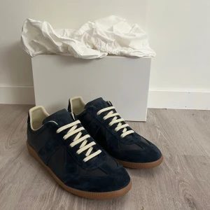 Maison margiela gats - Skick: 9/10 (som nya)                                                    Storlek: EU 41                                                                        Färg: Navy                                                                       Äkta: Ja! Har gått igenom en äktahets kontroll (bildbevis skickas privat)                                                Og: Yes allt og är med: 2st Dustbag, box, skor och tags på sidan av boxen. Vid frågor eller önskas fler bilder är det bara att höra av sig!