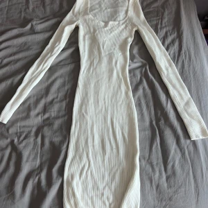 Vit klänning - Snygg vit ribbad klänning från FB Sister i storlek XXS. Klänningen är långärmad, figurnära och har en rundad urringning. Perfekt för dig som gillar en enkel men stilren look.💕