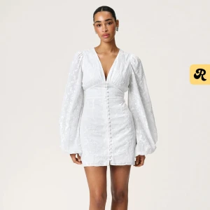 Adoore Florence dress vit  - Säljer min Superfina vita Adoore florence dress i strl 38. Endast använd en gång så är i princip i nyskick,  klänningen har en djup v-ringning, puffiga långärmar och knappar framtill. Klänningen har broderade blommor i tyget och markerad midja för en snygg siluett. En skit snygg sommarklänning!!!