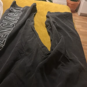 Svarta mjukisbyxor från zara - Svarta mjukisbyxor stor vit logga längs ena benet. Byxorna har resår i midjan och är tillverkade i ett mjukt material som känns riktigt skönt. Perfekta för en chill och avslappnad stil.