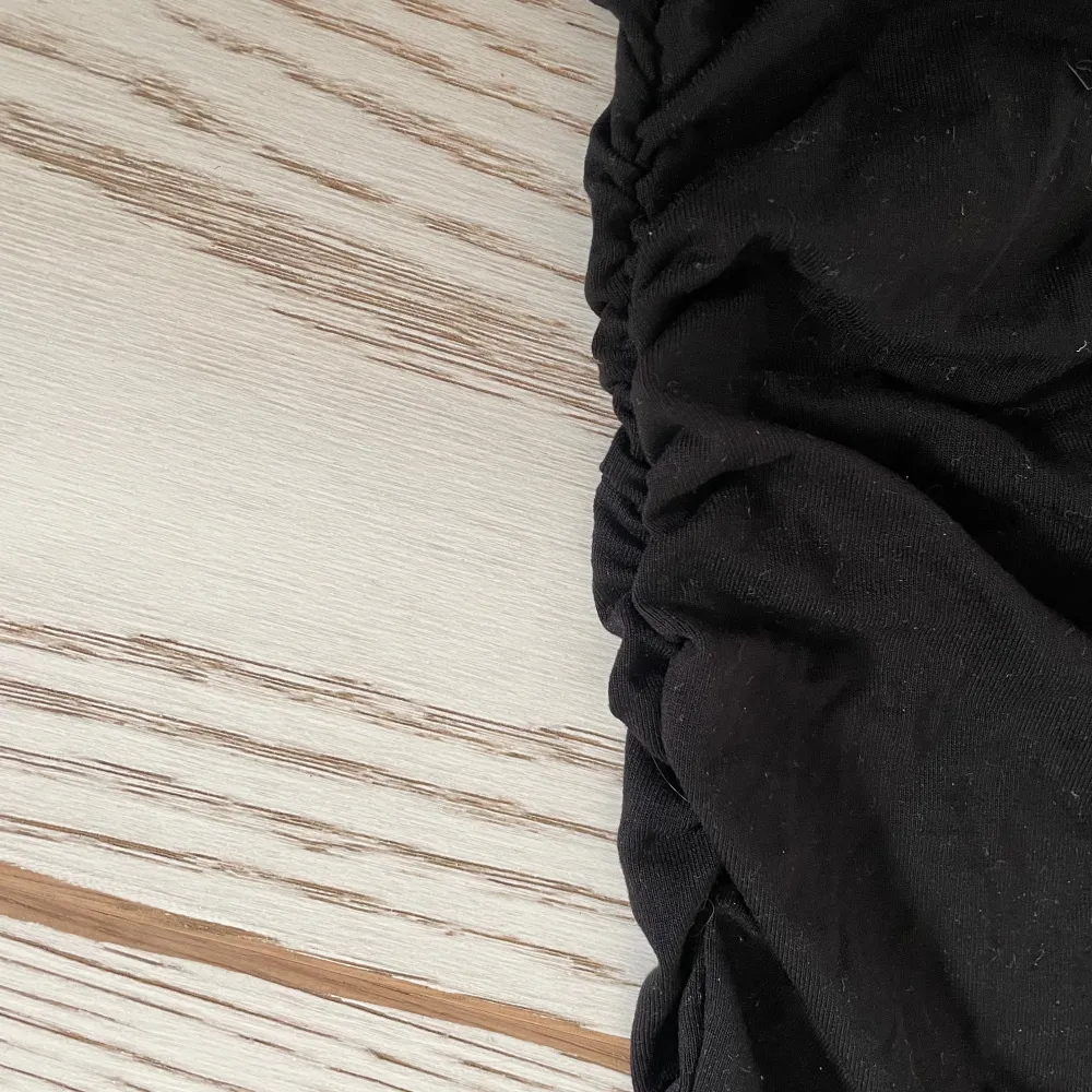 Snygg svart oneshoulder topp med en tight passform. Perfekt för en stilren look. Toppen har korta ärmar och är tillverkad i ett mjukt material. Från ginas soft touch kollektion slut i lager använd en gång och i nyskick . Yläosat.
